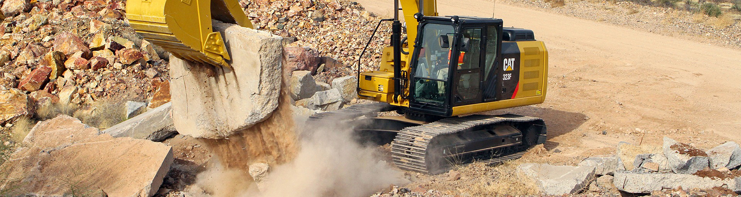 Excavadora con una piedra. Empresas de excavaciones en Jaén